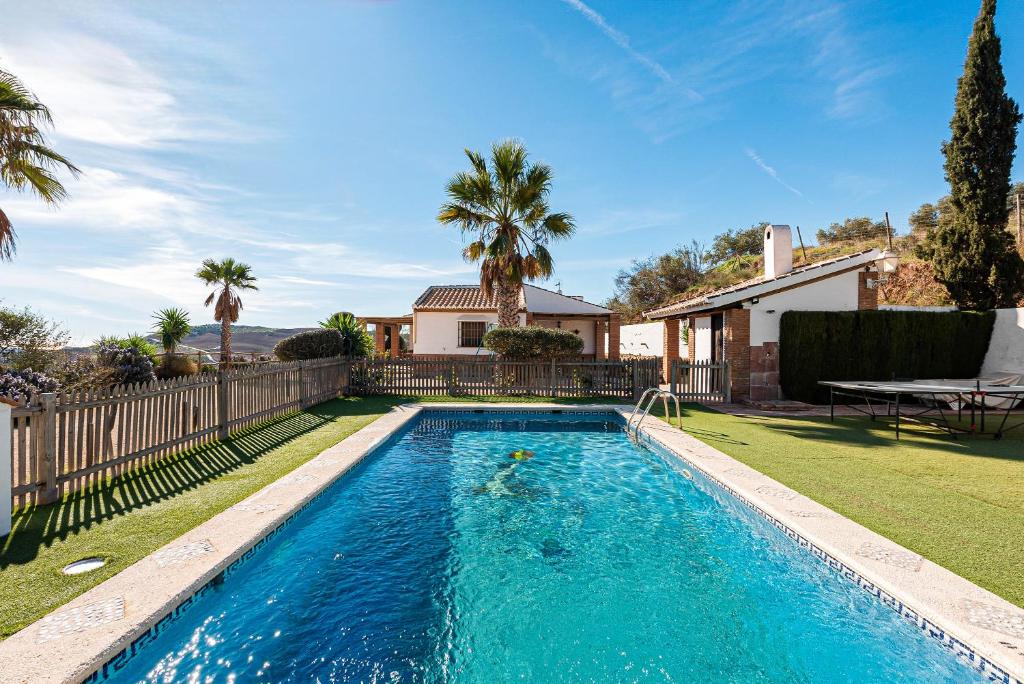 a swimming pool in the yard of a house at Casa Rural La Herradura in Antequera