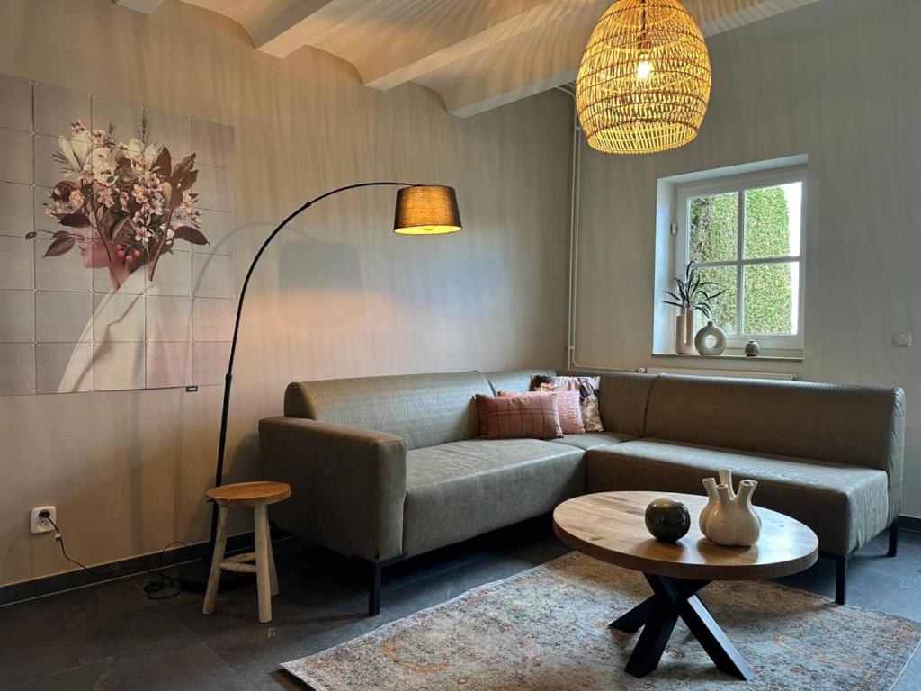 a living room with a couch and a table at Authentieke 4 persoons cottage vlakbij Valkenburg in Voerendaal