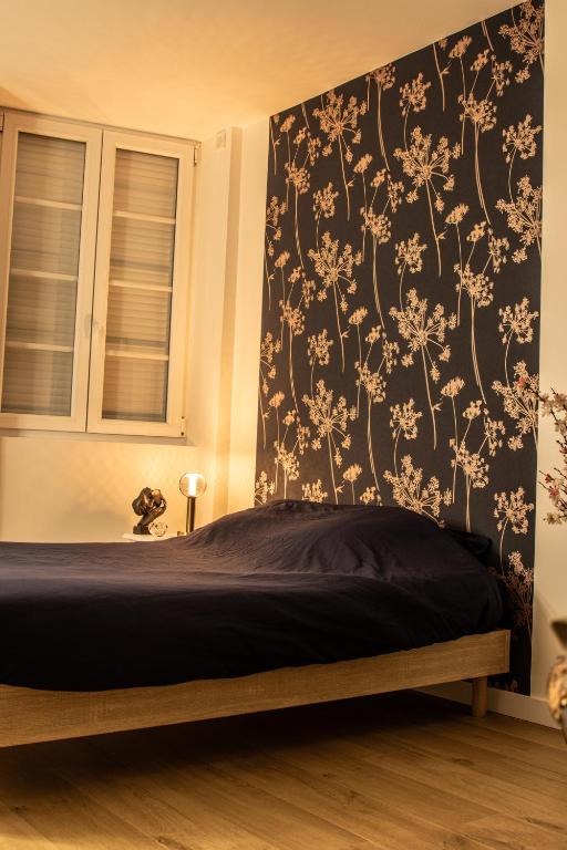 une chambre avec un lit avec un papier peint fleuri dans l'établissement Cosy Haven Studio rénové, élégant Pougues les Eaux, à Pougues-les-Eaux