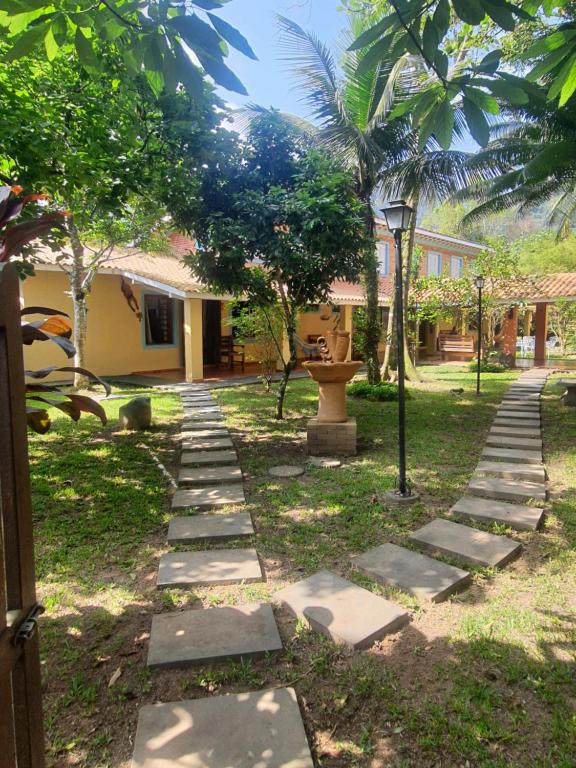 a garden with stepping stones in front of a house at Suítes Quintal de Lázaro 3 in Ubatuba
