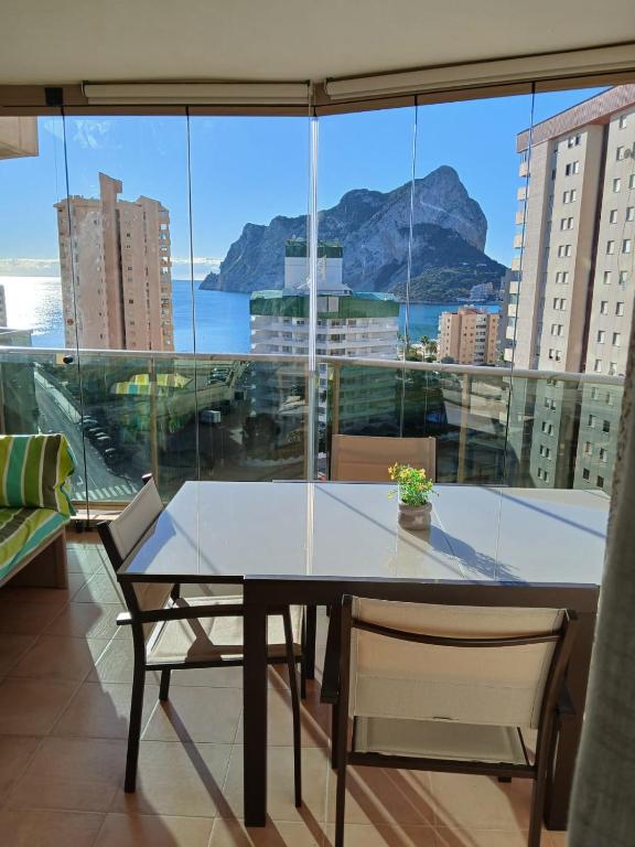a table and chairs in front of a large window at Esmeralda Suites Calpe in Calpe