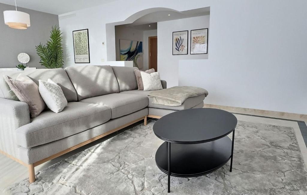 una sala de estar con un sofá y una mesa en Beautiful penthouse apartment with three large double bedrooms in Casares Costa, en Buenas Noches