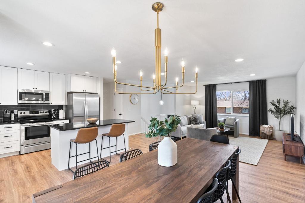 a kitchen and living room with a table and a chandelier at Spacious and Cozy 5 Bed 3 Bath Vacation House W 2 King 3 Queen! Sleep 12! 15Min to Red Rocks in Arvada