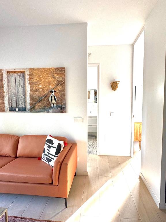 a living room with a couch and a painting on the wall at Appartement NoBe Es Pujols proche plage, vue mer in Es Pujols