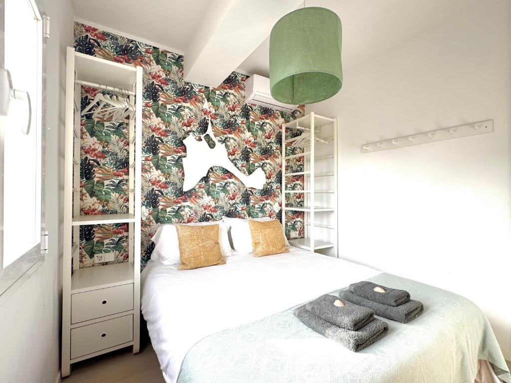 a bedroom with a bed and a floral wallpaper at Appartement NoBe Es Pujols proche plage, vue mer in Es Pujols