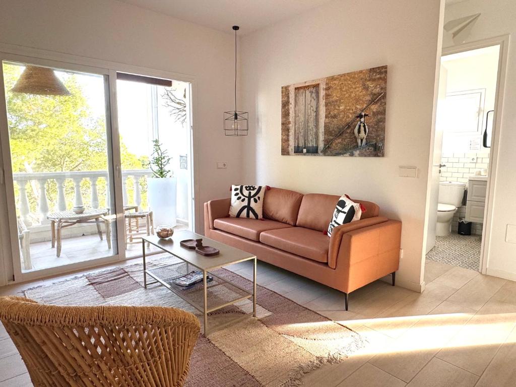 a living room with a couch and a table at Appartement NoBe Es Pujols proche plage, vue mer in Es Pujols