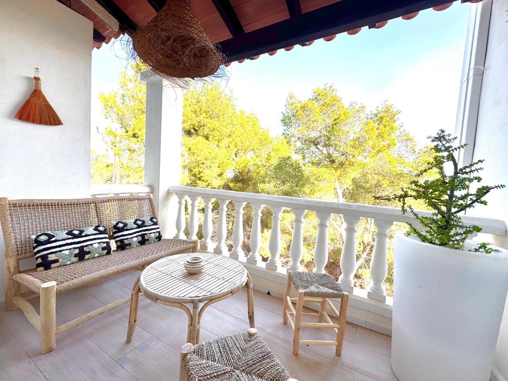 a porch with a bench and chairs and a table at Appartement NoBe Es Pujols proche plage, vue mer in Es Pujols