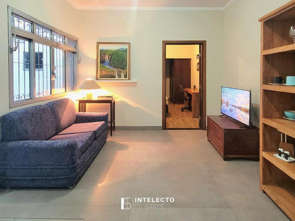 a living room with a couch and a tv at Casa - Centro Px Matriz c/ Churrasqueira, 2 Suítes in Poços de Caldas
