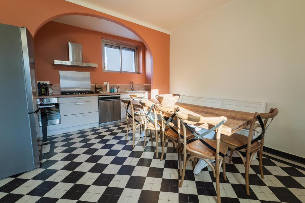 a kitchen with a table and chairs in a room at La Pictave, maison poitevine à 5 mn du Futuroscope in Chasseneuil-du-Poitou