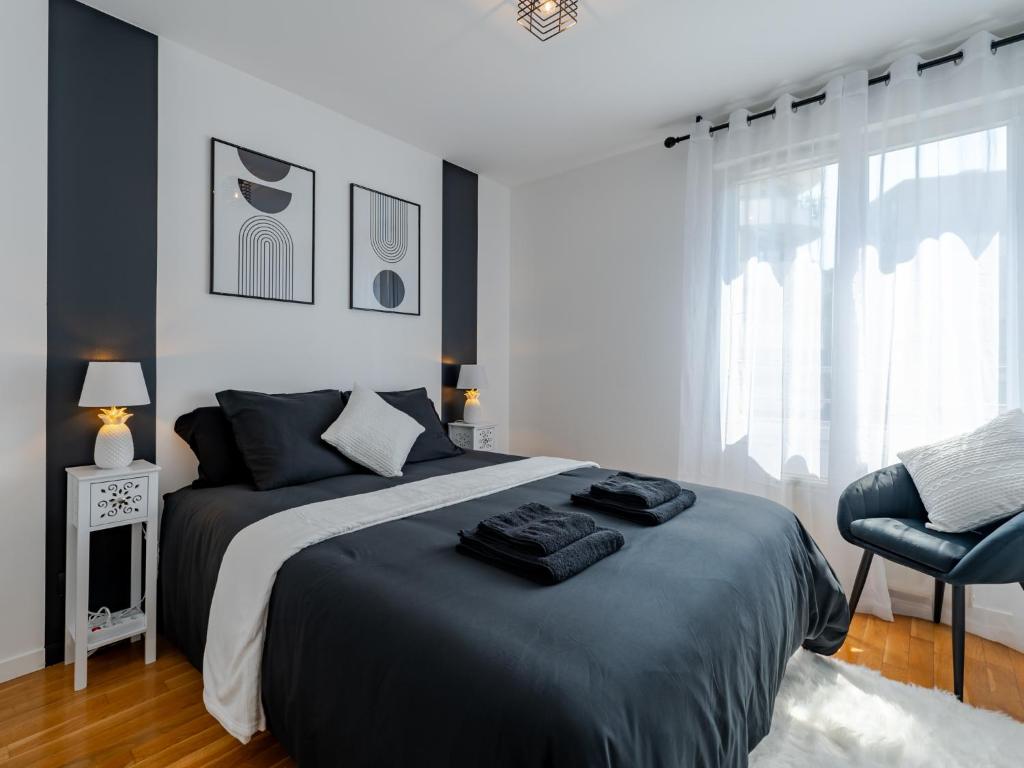 une chambre avec un grand lit et une chaise dans l'établissement L'Arlequin Familial et Reposant, à Villeurbanne