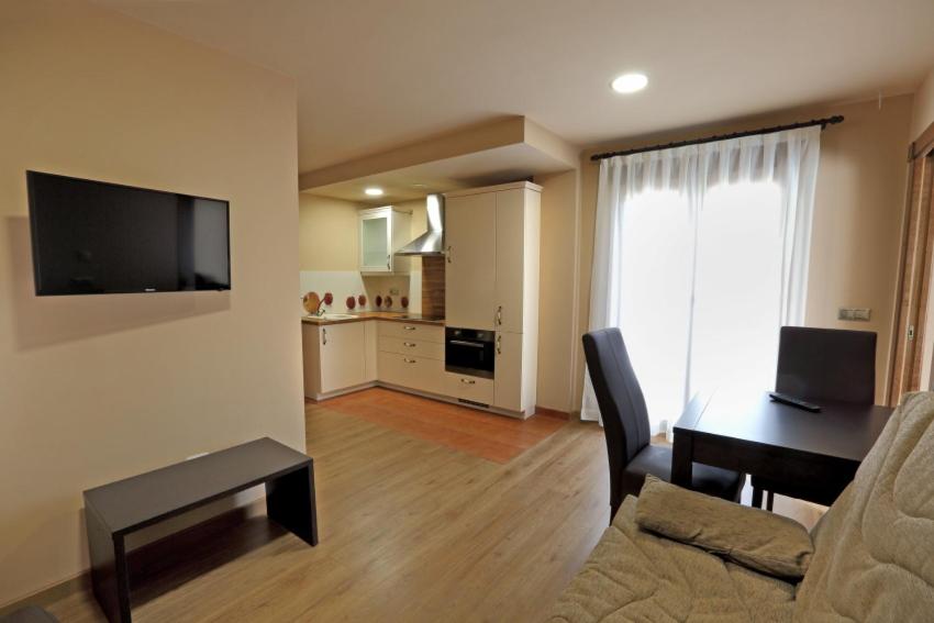 salon z kanapą, stołem i telewizorem w obiekcie Apartamentos Villa Sofía w mieście San Vicente de la Barquera