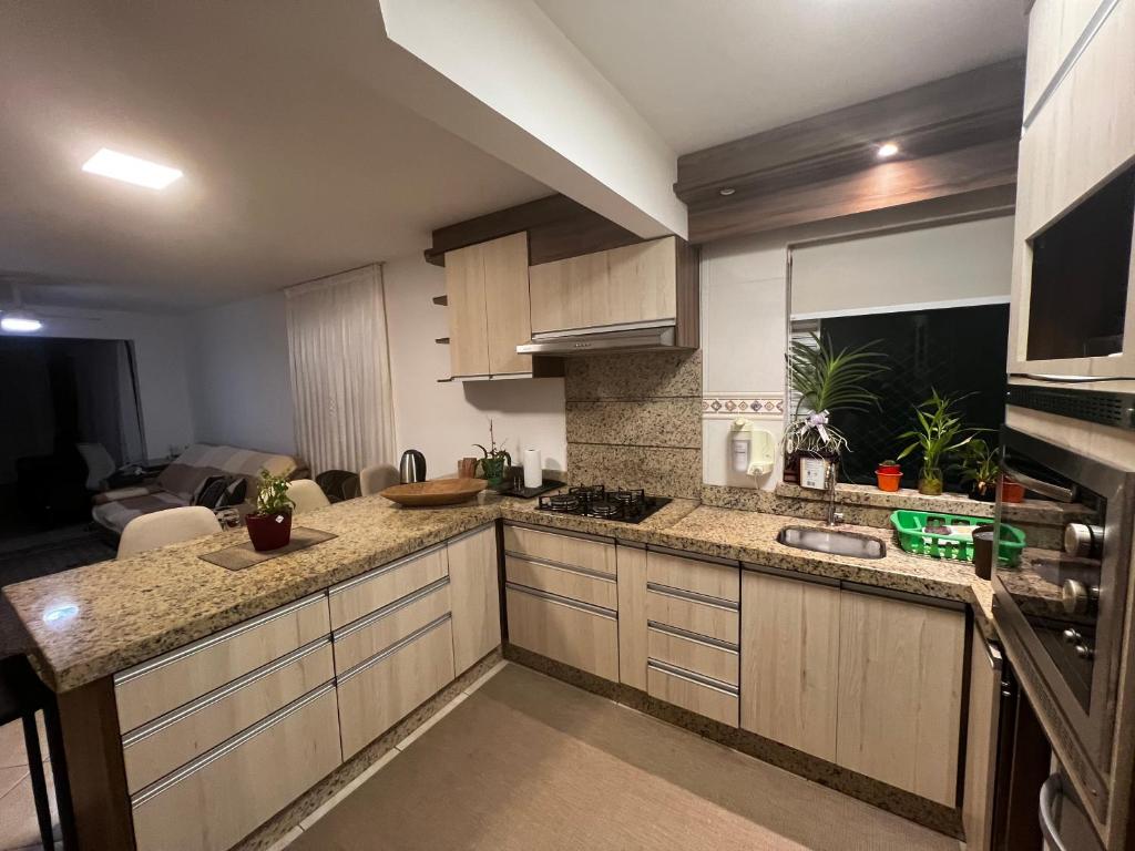 una cocina con fregadero y encimera en Apartamento Frente Mar Itapema, en Itapema