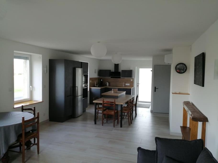 une cuisine et une salle à manger avec une table et des chaises dans l'établissement Meublé Climatisé 75 M2, à Souvans