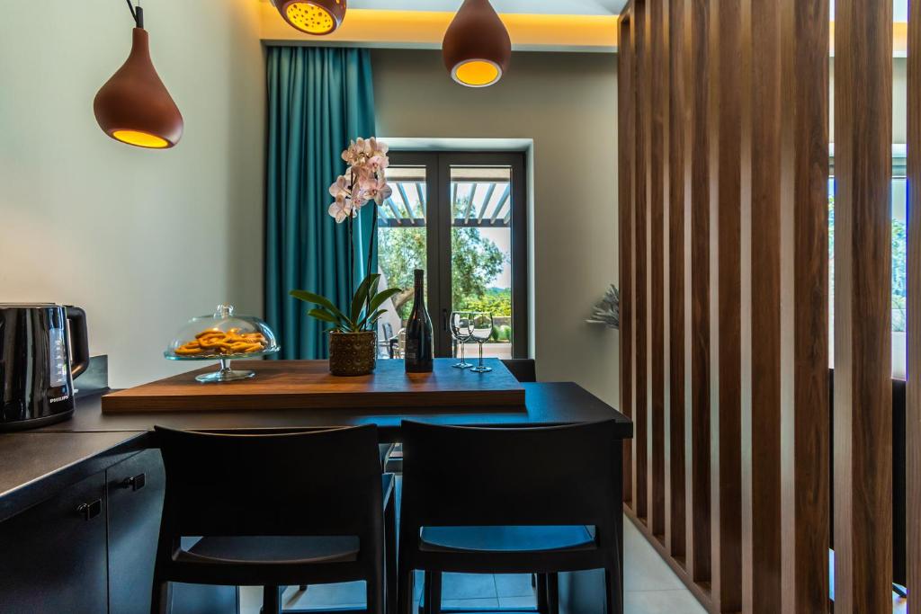 a kitchen with a dining table and two chairs at Nestor Luxury Villas in Romanu