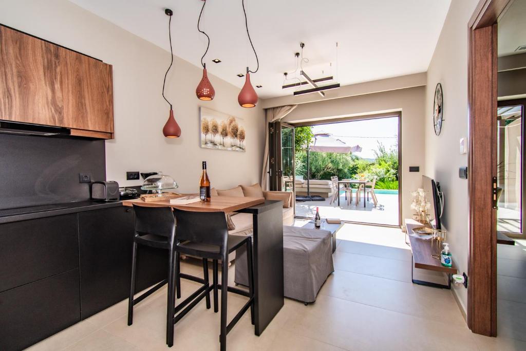 a kitchen with a table and chairs in a room at Nestor Luxury Villas in Romanu