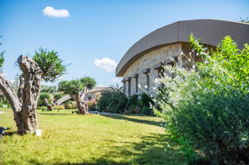 a building in a park with a green yard at Nestor Luxury Villas in Romanu