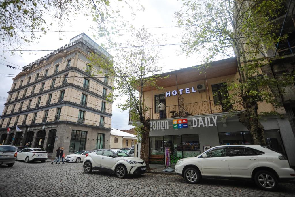 a street with cars parked in front of a hotel at hWB in Kutaisi