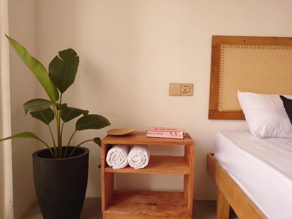 a bedroom with a plant and a table with towels at Balazo in Ahangama