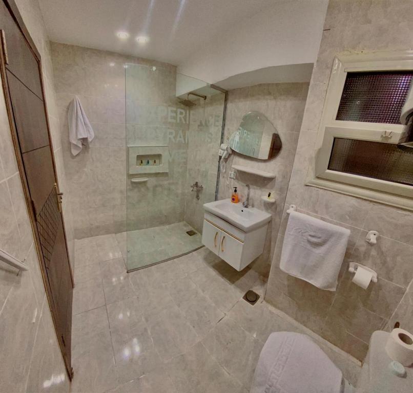 un bagno con doccia, WC e lavandino di Experience Pyramids VIEW a Il Cairo