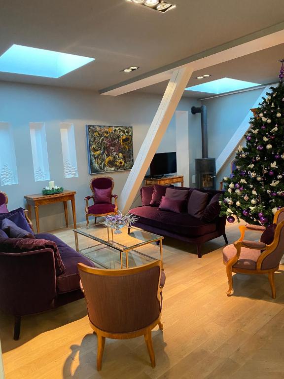 un salon avec un arbre de Noël au milieu dans l'établissement L'Écrin de Colmar - Hypercentre - Garage privé, à Colmar