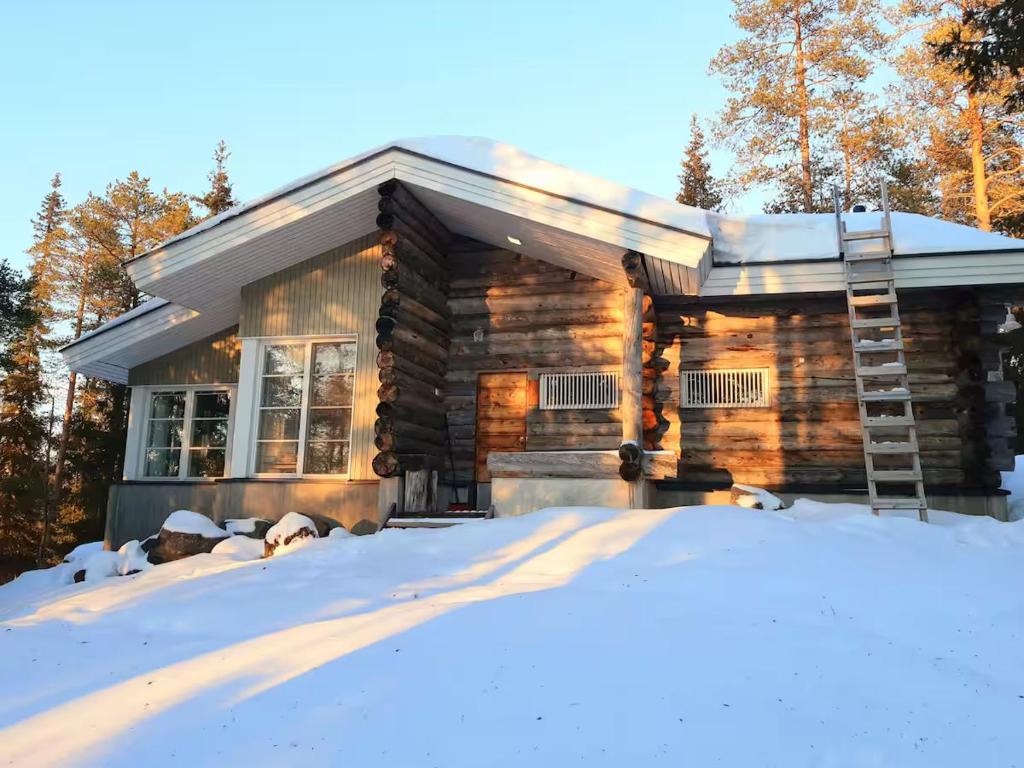 une cabane en rondins dans la neige dans l'établissement Ruka Pyhäjärvenrinne, à Kuusamo