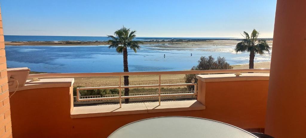 balcón con vistas a la playa y a las palmeras en Vista Atlántico, en Isla Cristina