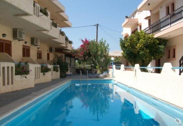 a swimming pool in front of a building at Hotel Elida in Platanes