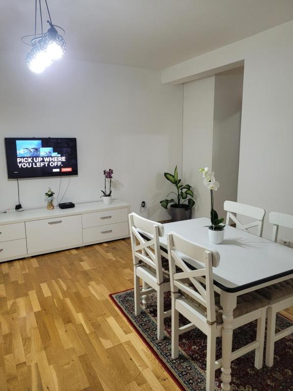 Un comedor con mesa y sillas y un televisor. en Apartment Stadion, en Tuzla
