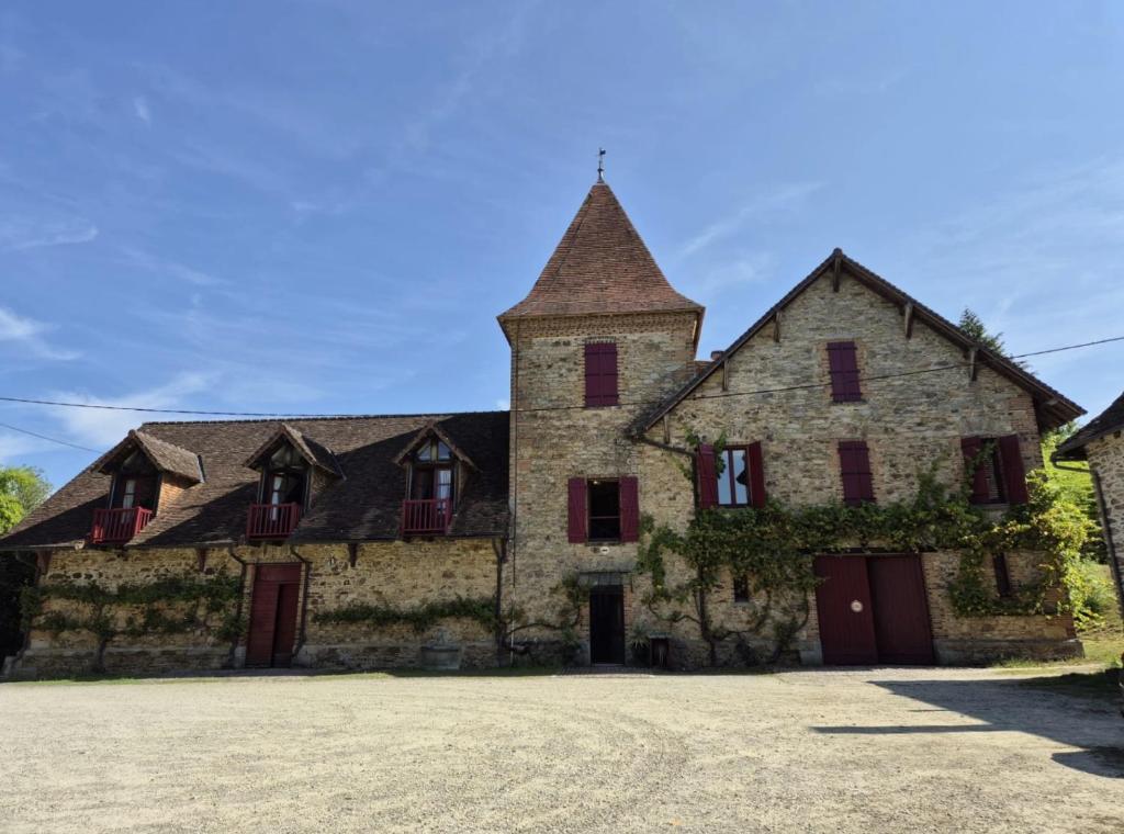 a large stone building with a tower at Appartement des écuries in Château-Chervix