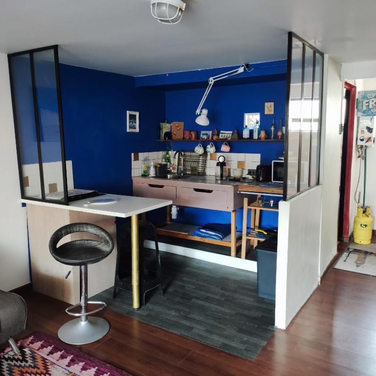 een kamer met een bureau en een blauwe muur bij Estudio21centro in Arica