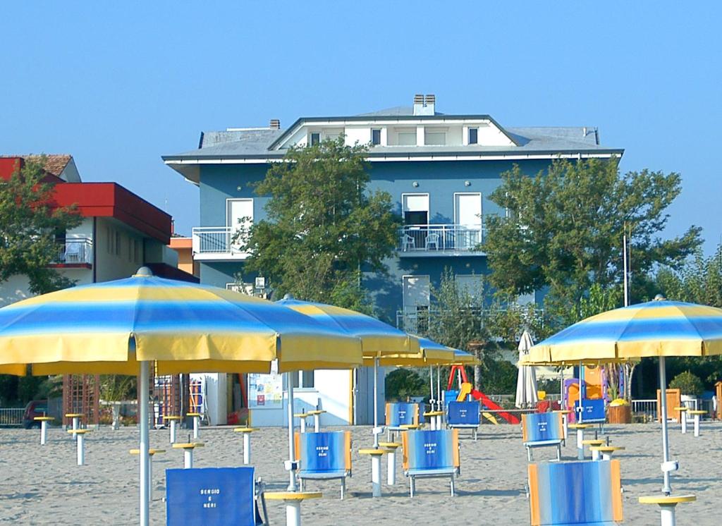 サン・マウロ・ア・マーレにあるPiccolo Hotel Aristonの建物の前のビーチ(椅子、パラソル付)