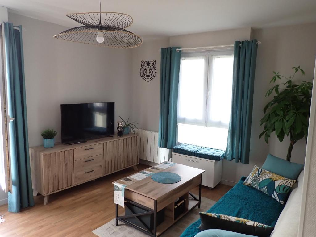 un salon avec un canapé et une télévision dans l'établissement Appart Mémorial 2-4pers, à Caen