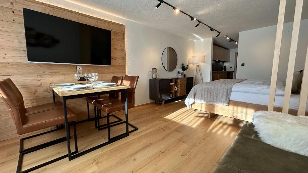 Un dormitorio con una cama y un escritorio con televisión. en WALDNEST - Apartment Seefeld, en Seefeld in Tirol