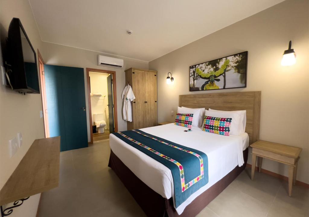 a bedroom with a large bed and a television at Resort Quinta Santa Barbara in Pirenópolis