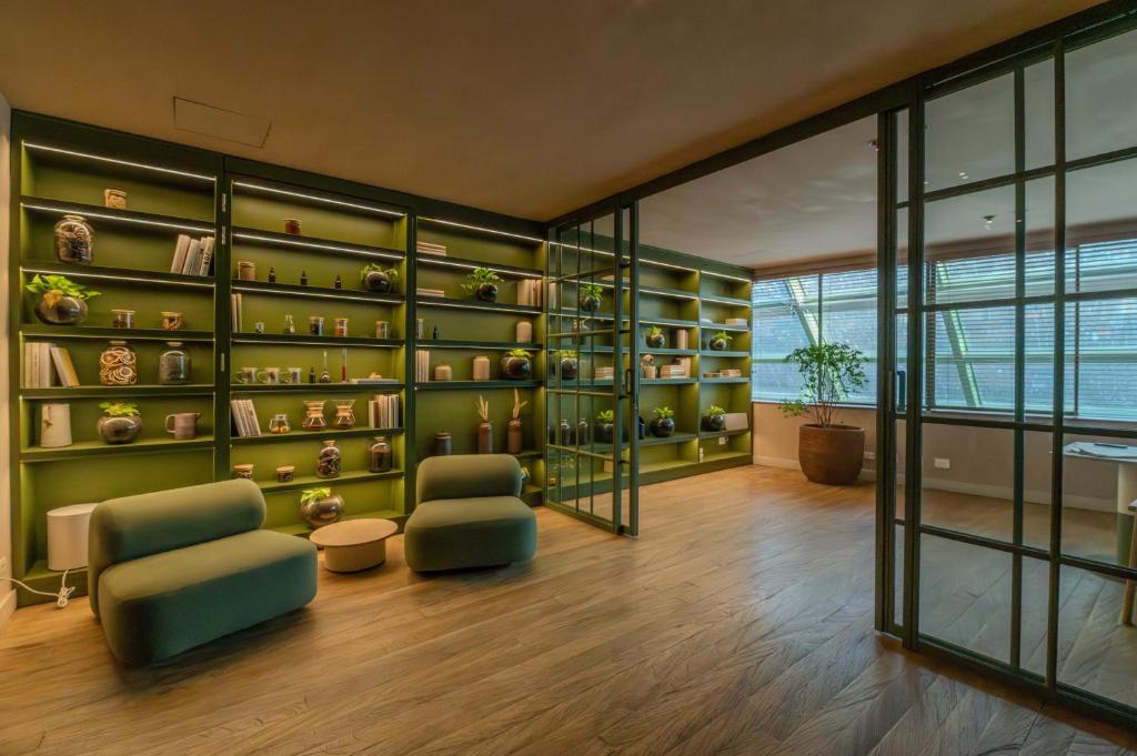 a living room with green shelves and two chairs at The Charlee Hotel in Medellín