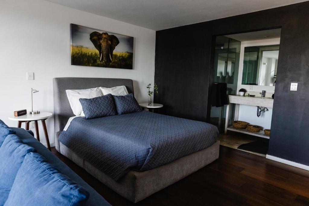 a bedroom with a bed and a couch and a mirror at Loft 44 puebla center by Rotamundos in Puebla