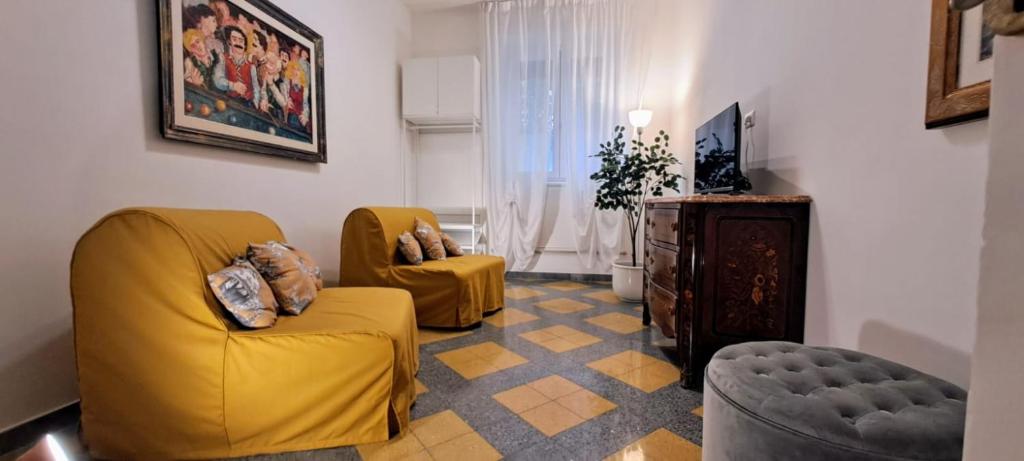 ein Wohnzimmer mit 2 gelben Stühlen und einem TV in der Unterkunft Machiavelli Forty Seven in Rom