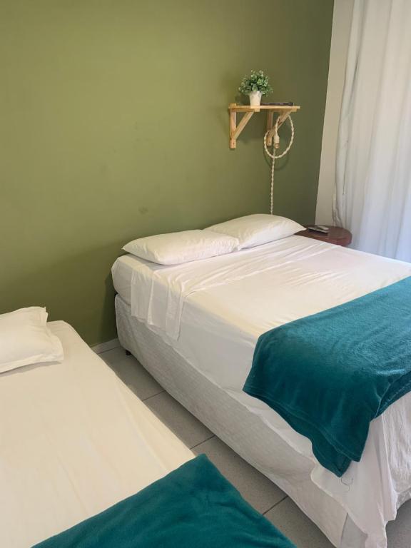 Zwei Betten in einem Schlafzimmer mit einem Regal an der Wand in der Unterkunft Chalé Park Mar, São José e Maragogi in São José da Coroa Grande