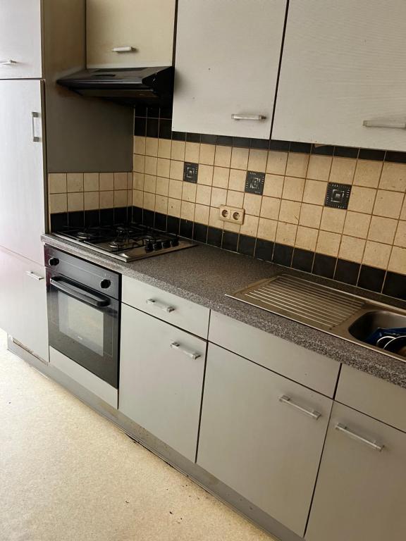 シャルルロワにあるOrléan 41 A centre-gare-aéroportのキッチン(白いキャビネット、コンロ、シンク付)