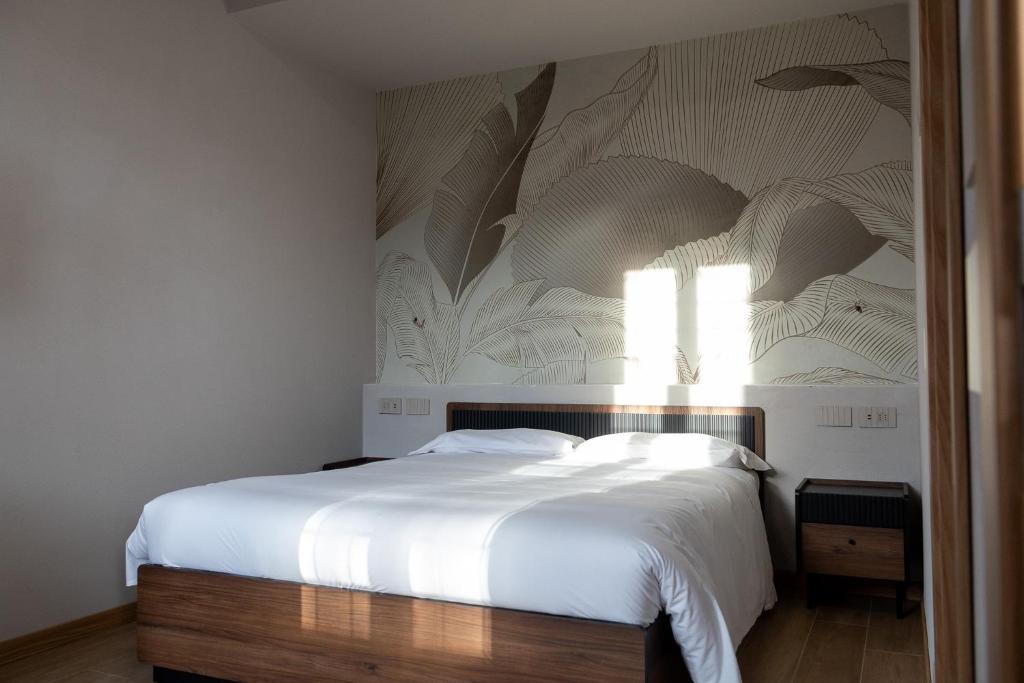 a bedroom with a large bed with a white bedspread at Locanda Borgovecchio in Manerbio