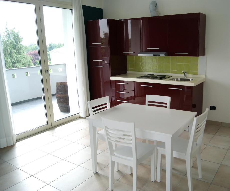 eine Küche mit einem weißen Tisch und weißen Stühlen in der Unterkunft Guest House Residence Malpensa in Case Nuove