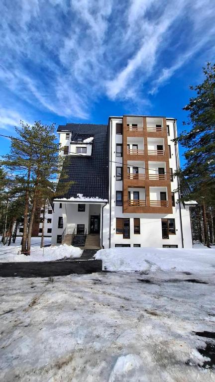 um grande edifício com neve em frente em Divcibarski Izvor Apartman 12 em Divčibare