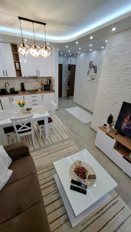 uma sala de estar com um sofá e uma mesa em Divcibarski Izvor Apartman 12 em Divčibare
