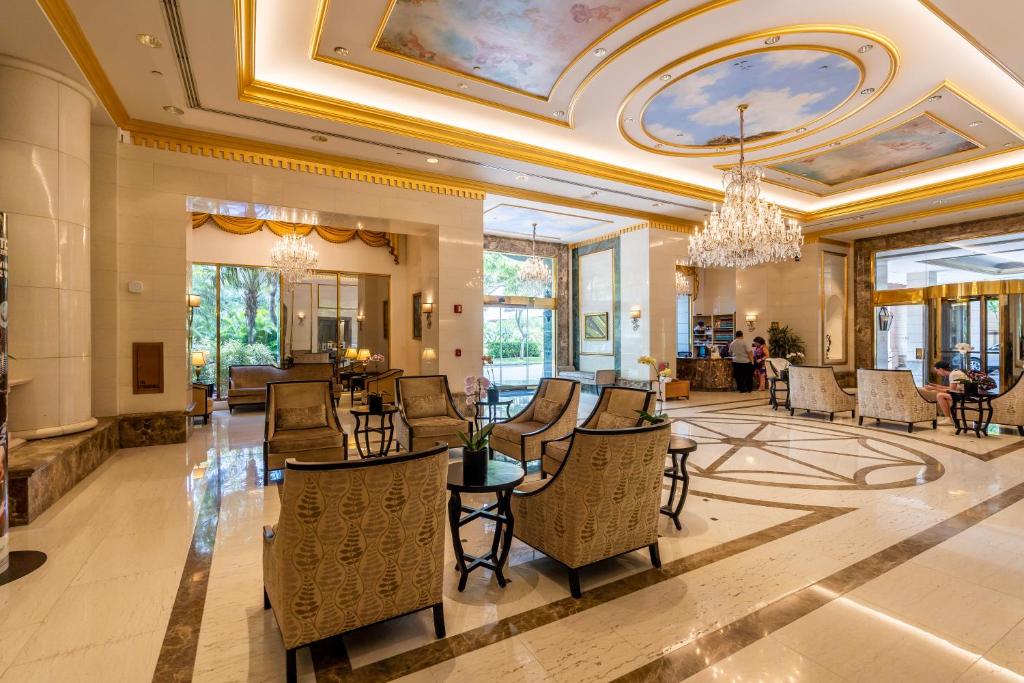 a lobby with chairs and tables and a chandelier at Royal Garden Waikiki - Ocean View - Resort Amenities in Honolulu