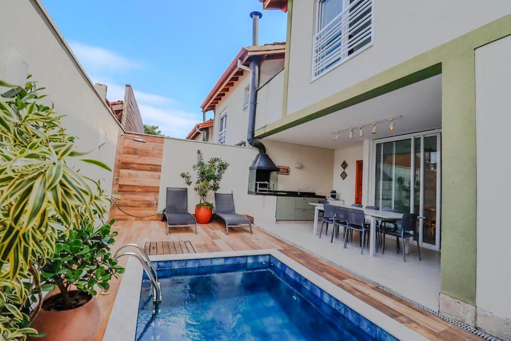 a backyard with a swimming pool and a house at 33hosts | Splendor Casa 10 · Serviço de Praia em Juquehy c/ Piscina Aquecida in São Sebastião