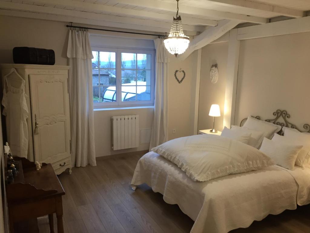 een slaapkamer met een wit bed en een raam bij Chambres d'hôtes Le Mont d'Anon in Goviller