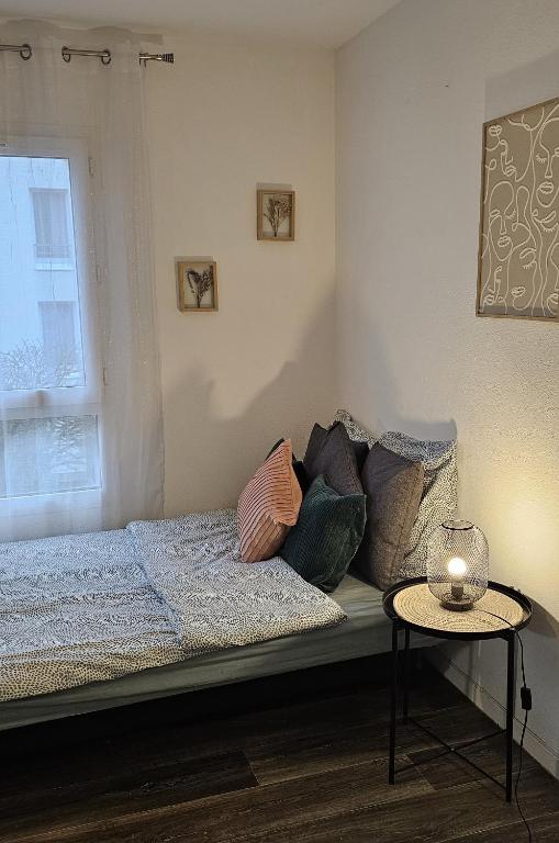 - une chambre avec un lit avec des oreillers et une table dans l'établissement Nid Paisible bord du Lac entre Disney et Paris, à Torcy
