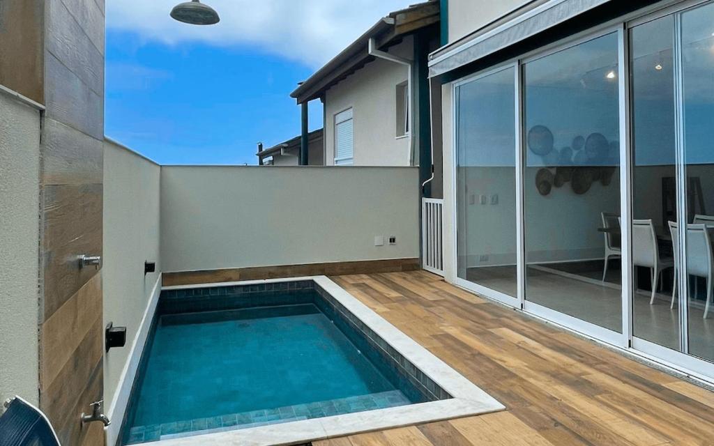 a swimming pool in the backyard of a house at Casa 14 · 4 Suítes | Piscina Privativa e Serviço De Praia in São Sebastião