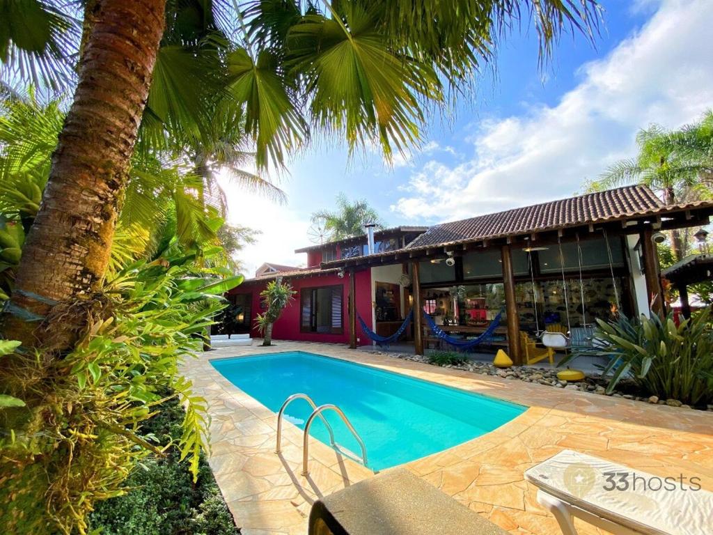 ein Swimmingpool vor einem Haus in der Unterkunft Casa Paraiso Praiano 2 minutos da praia · Barra do Una | Paraíso praiano a 120m da praia in São Sebastião