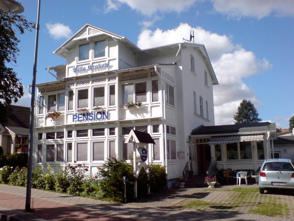 Un bâtiment blanc avec un panneau. dans l'établissement Pension Am Klünderberg, à Binz